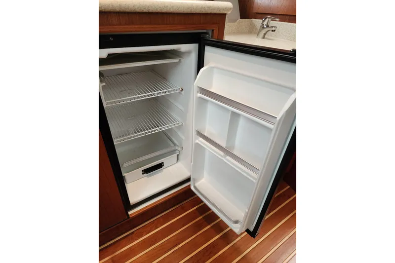 Slide: The Image of Open refrigerator in 2001 Tiara Yachts 3500 Open, showcasing interior shelves and door storage. - 11