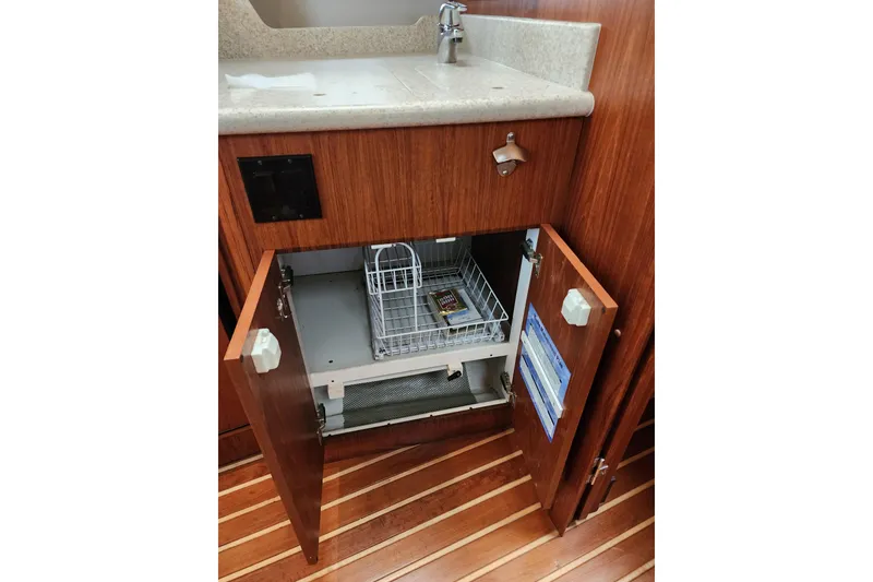 Slide: The Image of 2001 Tiara Yachts 3500 Open interior cabinet with open doors and storage basket. - 13