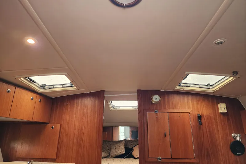 Slide: The Image of Interior of 2001 Tiara Yachts 3500 Open, featuring wooden cabinetry and ceiling hatches. - 16