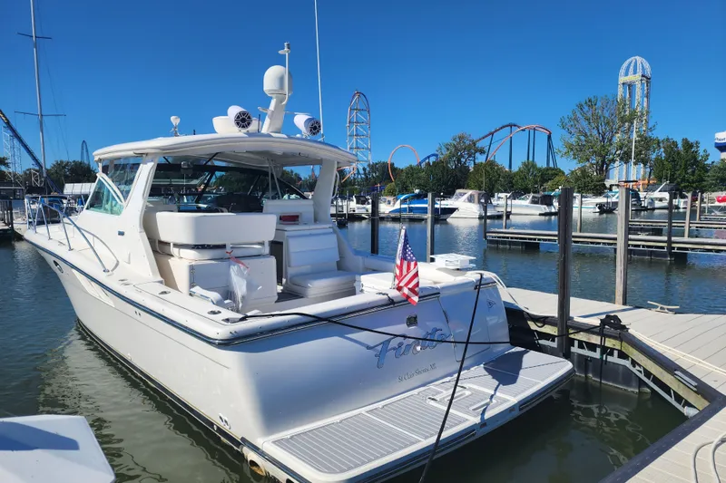 Slide: The Image of 2001 Tiara Yachts 3500 Open docked at marina with amusement park in background. - 2
