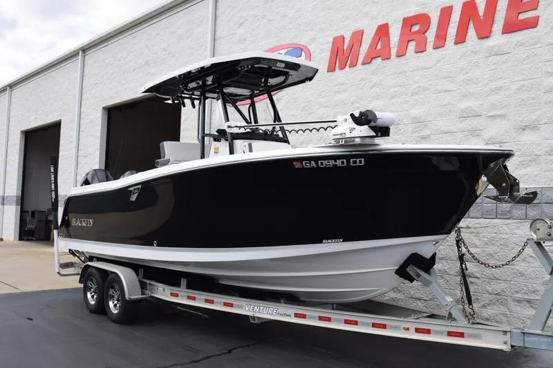 Slide: The Image of 2023 Blackfin 252 CC boat on trailer outside marine dealership. - 2