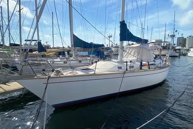 The Image of 1988 Morgan 44 sailboat docked in a marina under a clear blue sky. - 0