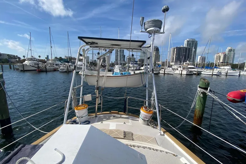 Slide: The Image of 1988 Morgan 44 sailboat docked in marina with city skyline and sailboats in background. - 10