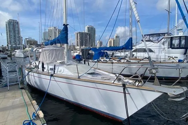 Slide: The Image of 1988 Morgan 44 sailboat docked in a marina with city skyline background. - 2