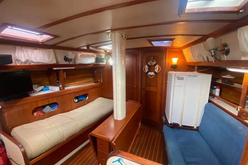 Slide: The Image of Interior of a 1988 Morgan 44 sailboat with wooden furnishings and cozy seating. - 20