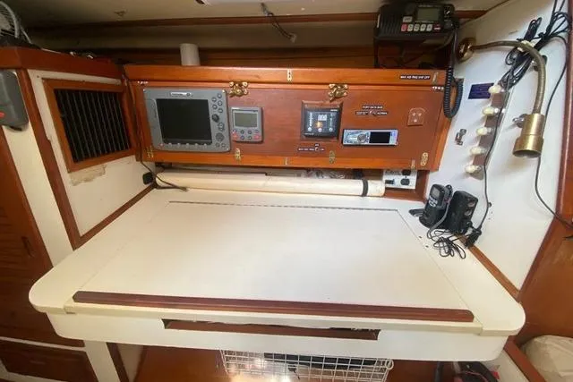 Slide: The Image of 1988 Morgan 44 yacht navigation station with electronic equipment and wooden cabinetry. - 26