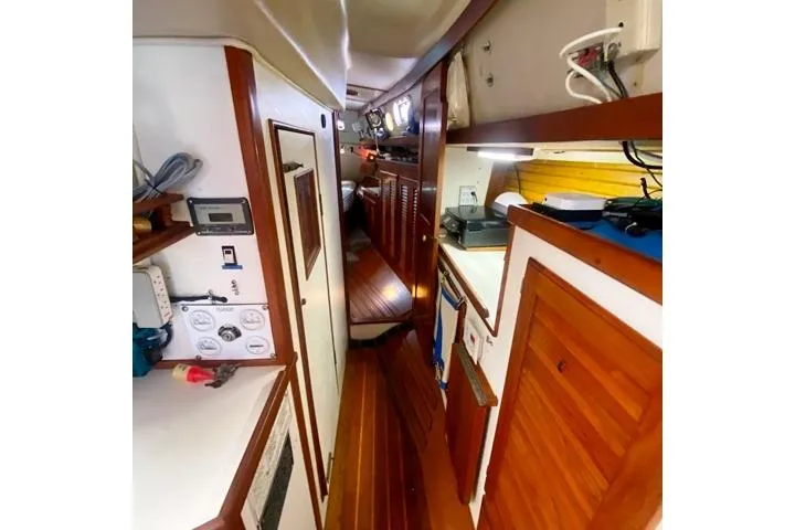 Slide: The Image of Interior of a 1988 Morgan 44 sailboat with wooden cabinetry and narrow passageway. - 27