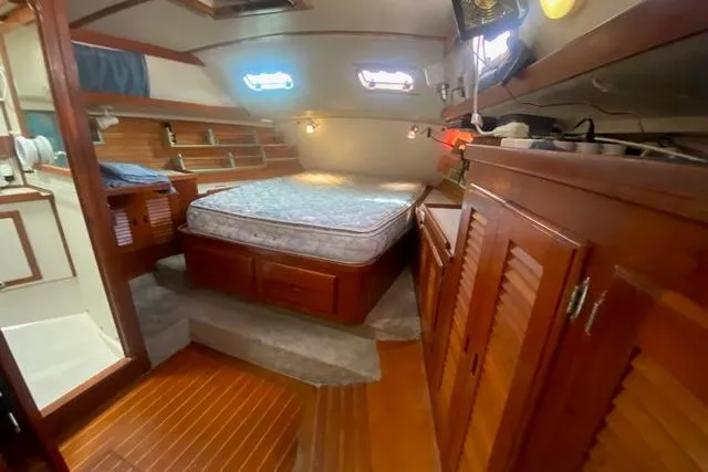 Slide: The Image of Cozy cabin interior of a 1988 Morgan 44 sailboat with wooden furnishings and a bed. - 28