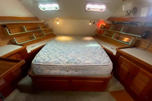 Slide: The Image of 1988 Morgan 44 yacht interior with cozy bed and wooden storage cabinets. - 29