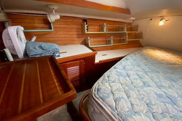 Slide: The Image of Cozy cabin interior of 1988 Morgan 44 sailboat with wooden shelves and bed. - 30