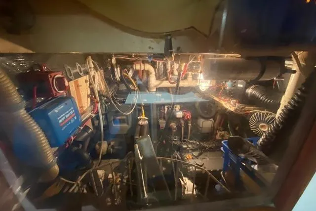 Slide: The Image of Engine room of a 1988 Morgan 44 sailboat, showcasing mechanical components and wiring. - 36