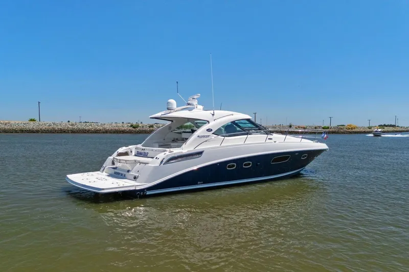 Slide: The Image of 2009 Sea Ray 470 Sundancer yacht on calm water under clear blue sky. - 11