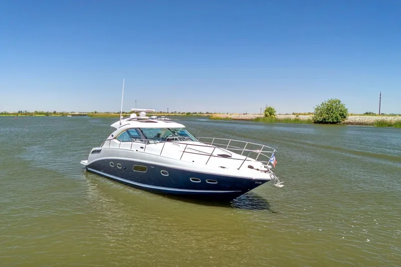 Slide: The Image of 2009 Sea Ray 470 Sundancer yacht cruising on a calm river under clear blue skies. - 13