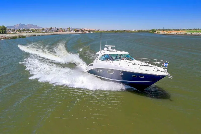 Slide: The Image of 2009 Sea Ray 470 Sundancer cruising on a scenic river under a clear blue sky. - 2