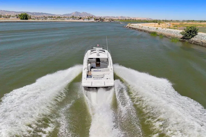 Slide: The Image of 2009 Sea Ray 470 Sundancer cruising on a scenic river with mountains in the background. - 4