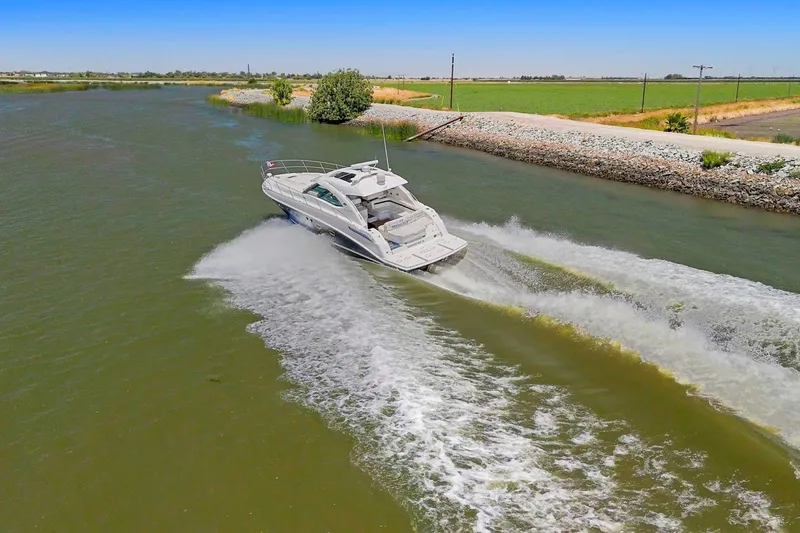 Slide: The Image of 2009 Sea Ray 470 Sundancer cruising on a scenic river under clear blue skies. - 5