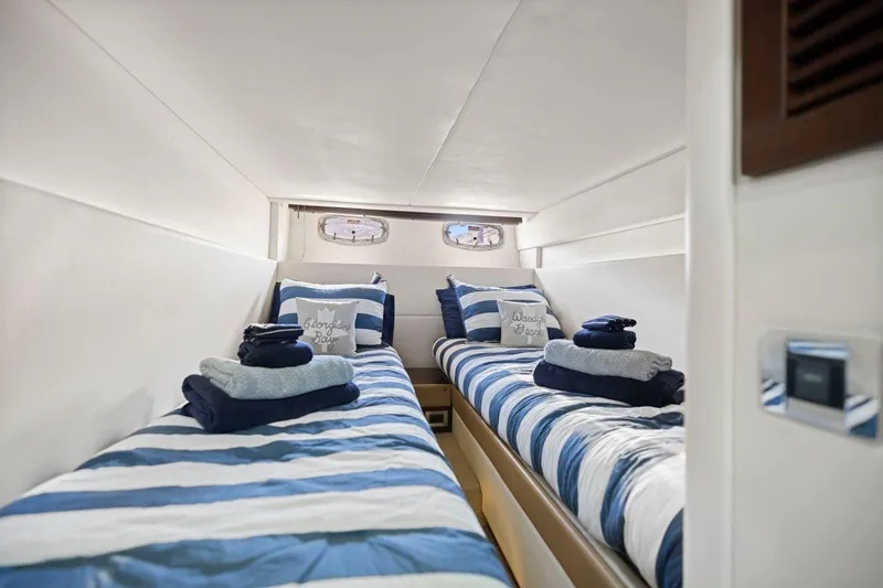 Slide: The Image of Interior cabin of 2009 Sea Ray 470 Sundancer with twin beds and striped bedding. - 54