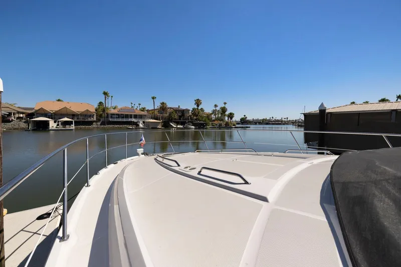 Slide: The Image of 2009 Sea Ray 470 Sundancer yacht docked in a serene waterfront setting. - 57