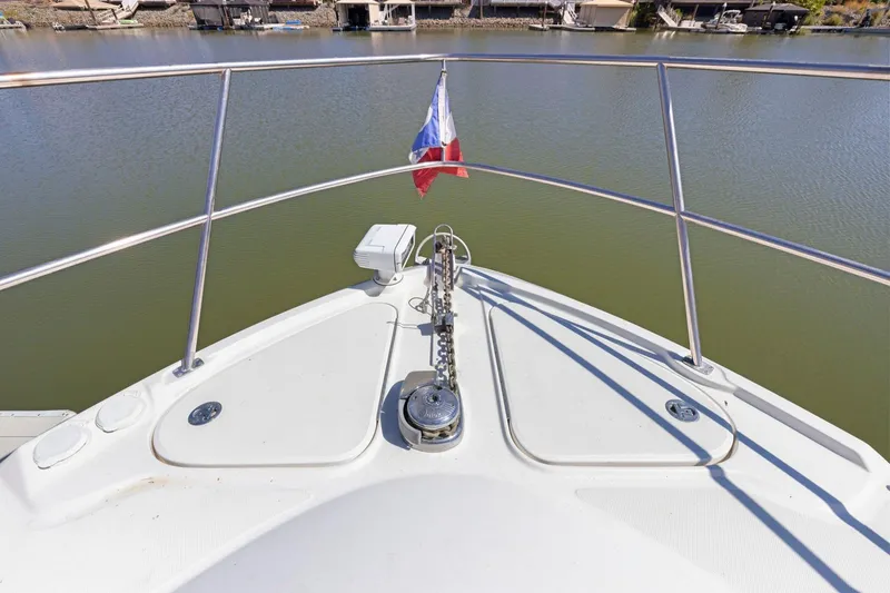 Slide: The Image of Bow of 2009 Sea Ray 470 Sundancer yacht with anchor and flag on calm water. - 59