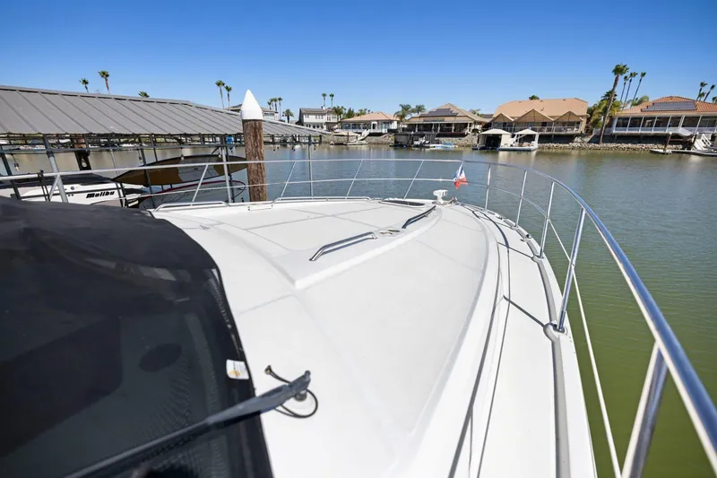 Slide: The Image of 2009 Sea Ray 470 Sundancer yacht docked in a marina with waterfront homes. - 62
