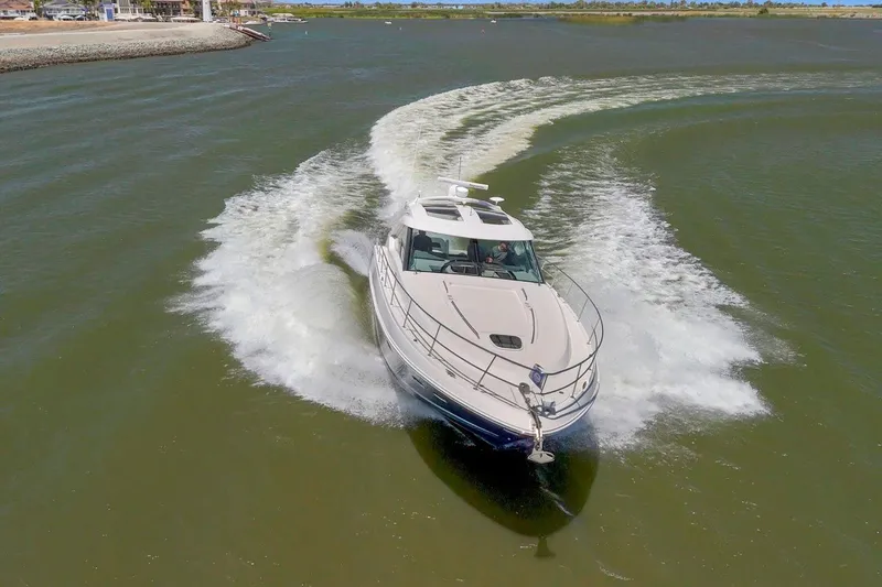 Slide: The Image of 2009 Sea Ray 470 Sundancer yacht cruising on open water, creating a dynamic wake. - 7