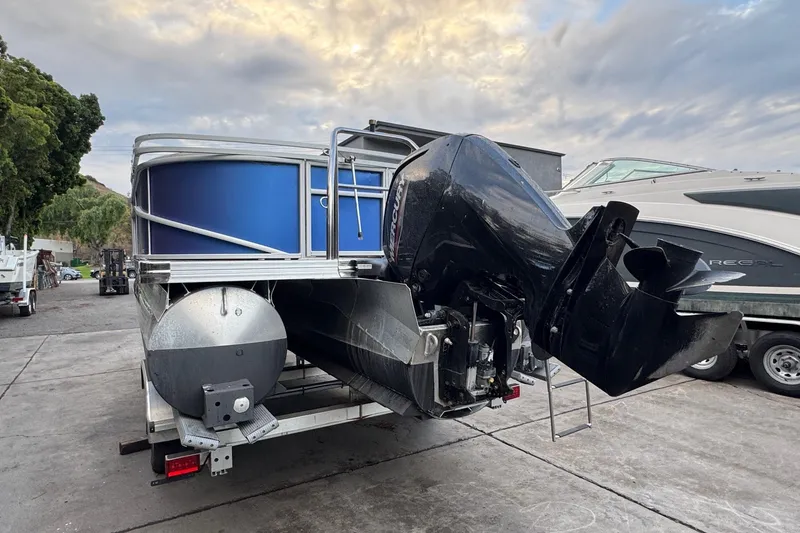 Slide: The Image of 2023 Barletta ARIA 22QC pontoon boat with powerful outboard motor, parked outdoors. - 12