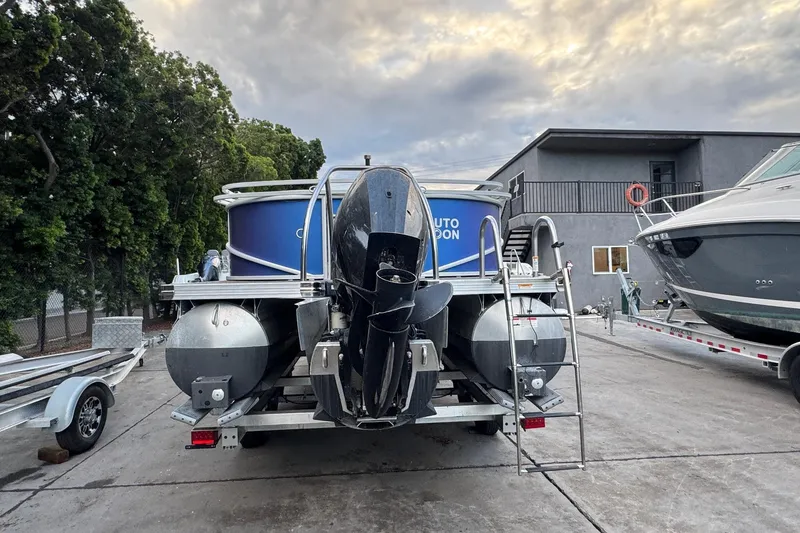 Slide: The Image of 2023 Barletta ARIA 22QC pontoon boat on trailer, parked outdoors. - 13