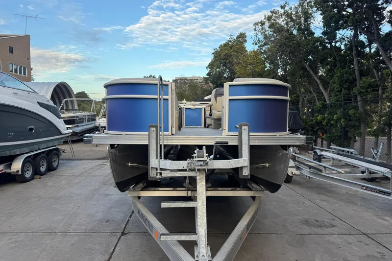 Slide: The Image of 2023 Barletta ARIA 22QC pontoon boat on trailer, parked outdoors. - 3