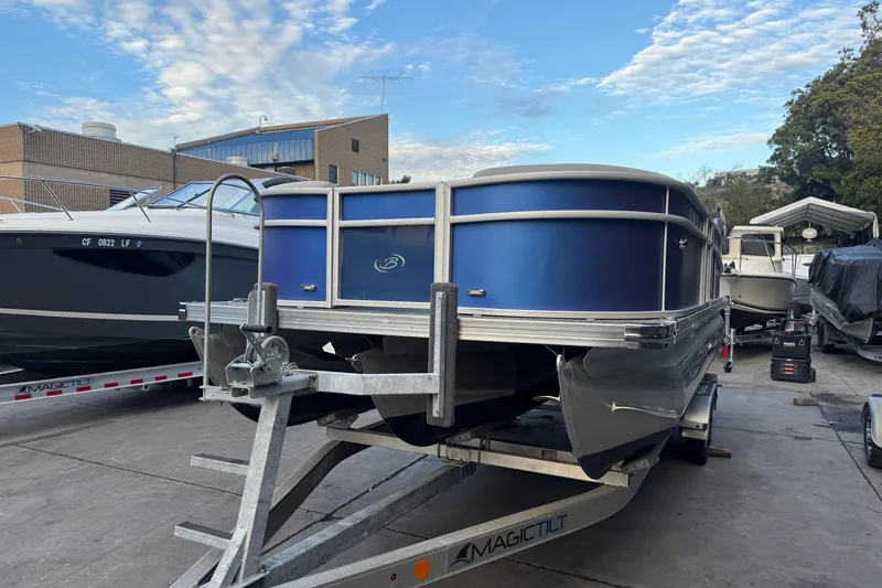 Slide: The Image of 2023 Barletta ARIA 22QC pontoon boat on trailer, parked outdoors. - 5