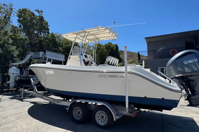 Slide: The Image of 2022 Cobia 237 Center Console boat docked under clear blue sky. - 7