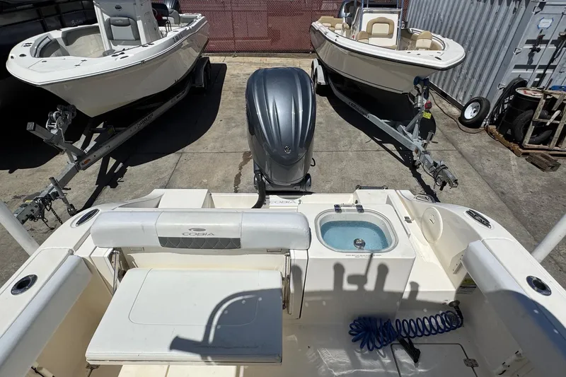 Slide: The Image of 2022 Cobia 237 Center Console boat docked under clear blue sky. - 8