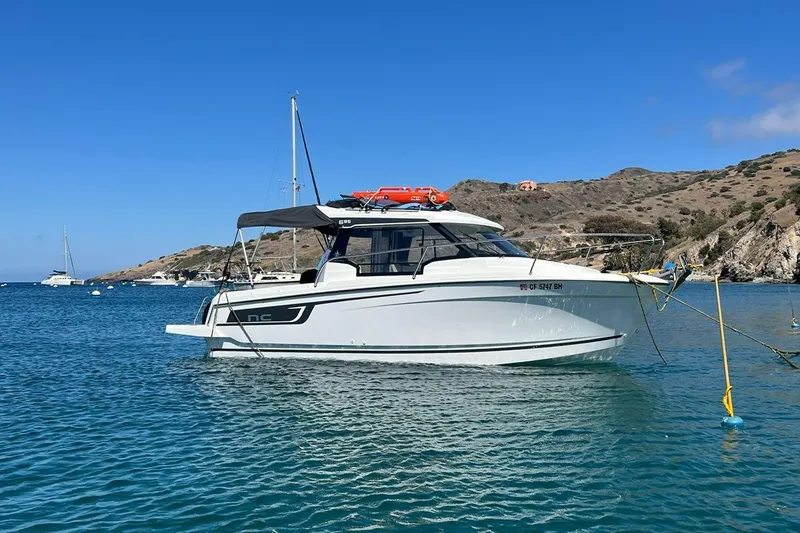 The Image of 2023 Jeanneau NC Weekender 695 Series 2 boat anchored in scenic coastal waters. - 0