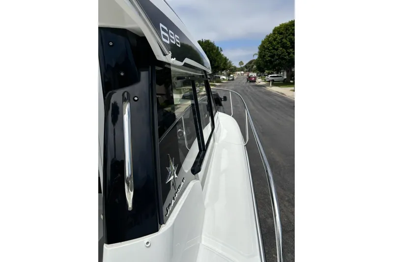 Slide: The Image of 2023 Jeanneau NC Weekender 695 Series 2 boat, side view on a street. - 11