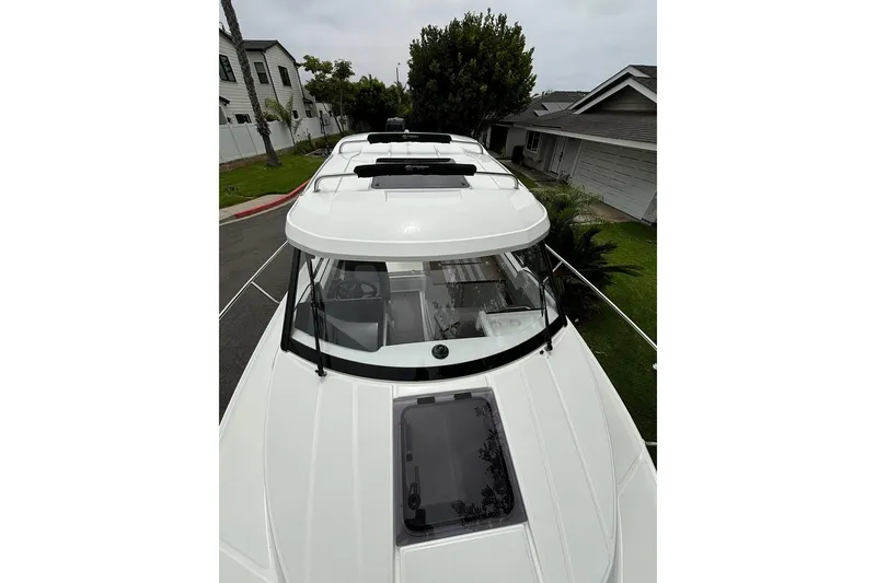 Slide: The Image of 2023 Jeanneau NC Weekender 695 Series 2 boat, top view, parked in residential area. - 30