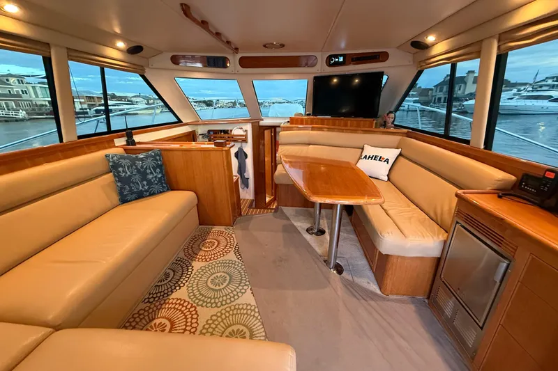 Slide: The Image of Interior of 2001 Riviera 40 Flybridge yacht with beige seating and wooden accents. - 11