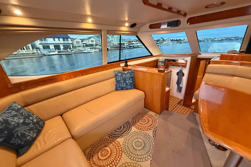Slide: The Image of Interior of 2001 Riviera 40 Flybridge yacht with cozy seating and waterfront view. - 12