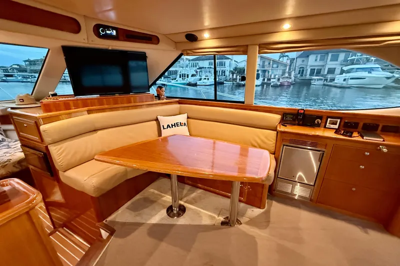 Slide: The Image of Luxurious interior of 2001 Riviera 40 Flybridge yacht with dining area and waterfront view. - 14