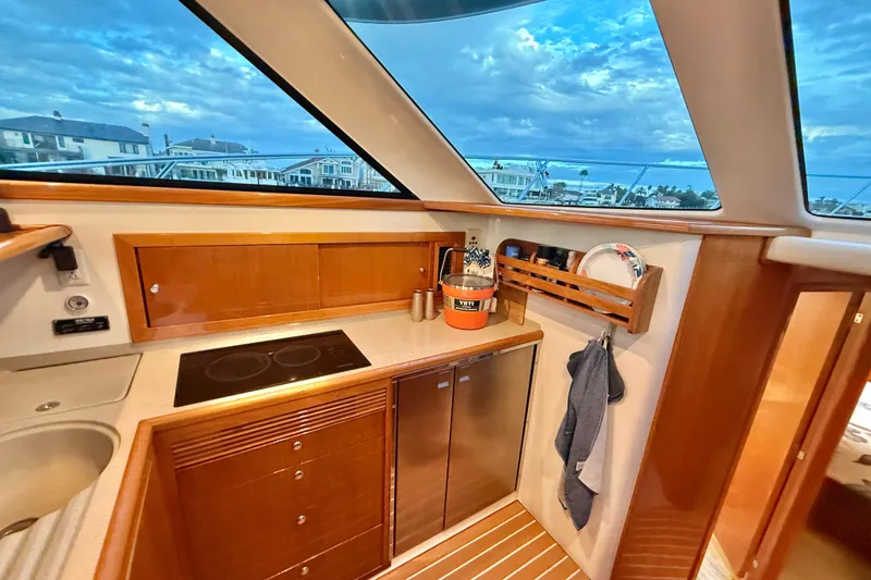 Slide: The Image of Luxurious 2001 Riviera 40 Flybridge yacht kitchen with modern amenities and scenic window view. - 20