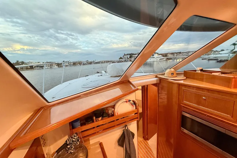 Slide: The Image of Interior view from 2001 Riviera 40 Flybridge yacht, showcasing elegant wood finish and scenic marina. - 21