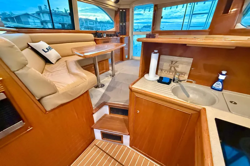 Slide: The Image of Luxurious interior of 2001 Riviera 40 Flybridge yacht with seating and kitchenette. - 24