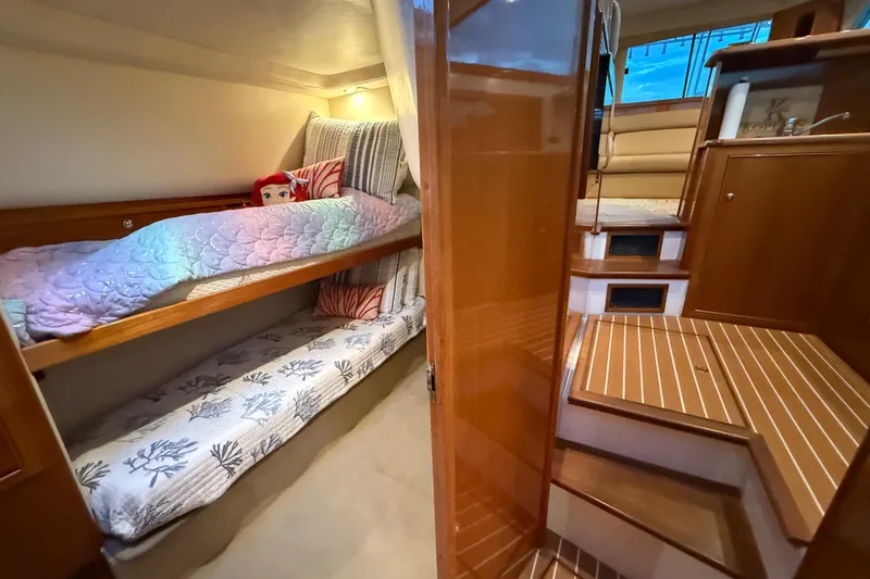Slide: The Image of Interior of 2001 Riviera 40 Flybridge yacht with cozy bunk beds and wooden finishes. - 26