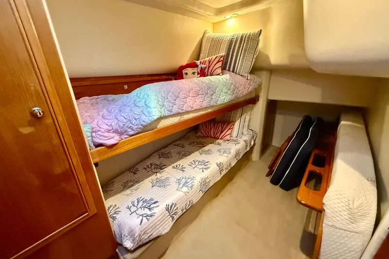 Slide: The Image of Cozy bunk beds in 2001 Riviera 40 Flybridge yacht cabin, featuring colorful bedding and cushions. - 27