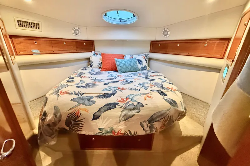Slide: The Image of Luxurious bedroom in 2001 Riviera 40 Flybridge yacht with tropical bedding and wood accents. - 29