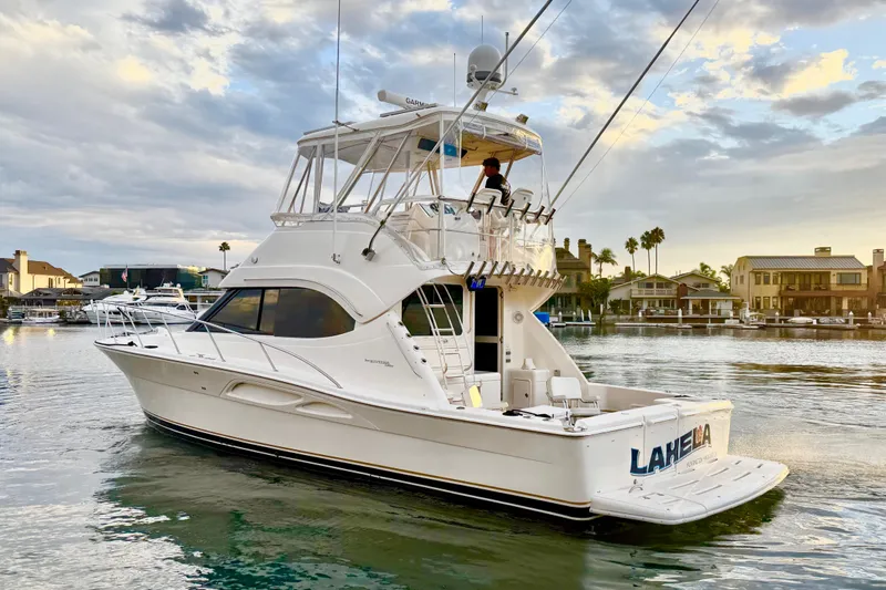 Slide: The Image of 2001 Riviera 40 Flybridge yacht cruising in a scenic waterfront setting. - 3