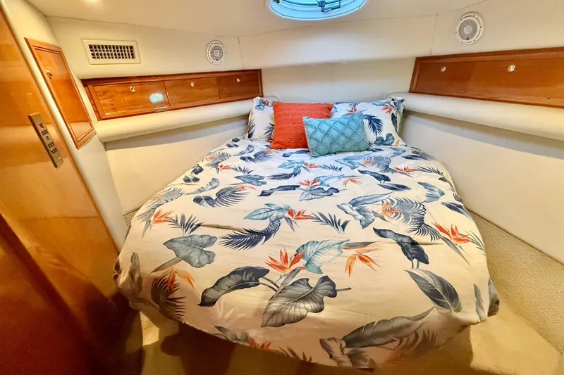 Slide: The Image of Cozy bedroom in 2001 Riviera 40 Flybridge yacht with tropical bedding and wooden cabinets. - 30
