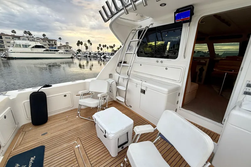 Slide: The Image of 2001 Riviera 40 Flybridge yacht deck with seating, ladder, and marina view. - 34