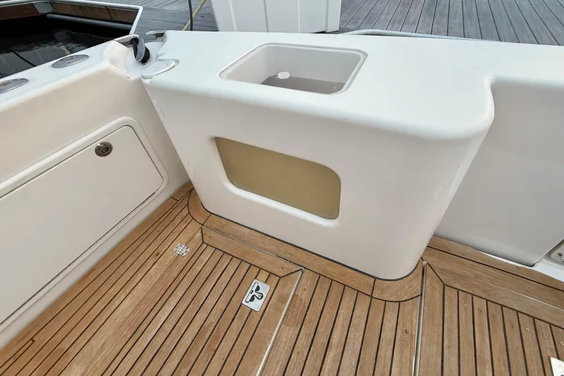 Slide: The Image of Riviera 40 Flybridge 2001 boat deck with wooden flooring and storage compartment. - 38