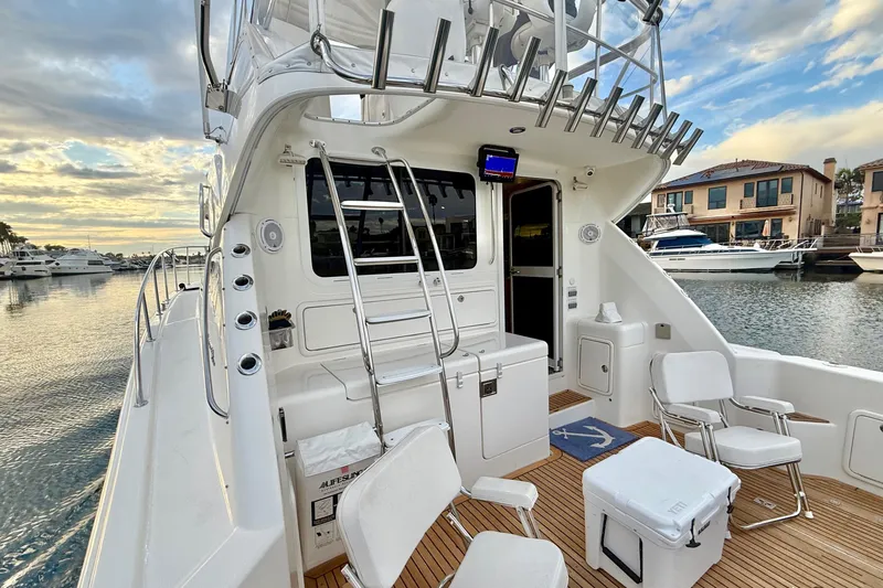 Slide: The Image of 2001 Riviera 40 Flybridge yacht with spacious deck, docked at marina during sunset. - 42