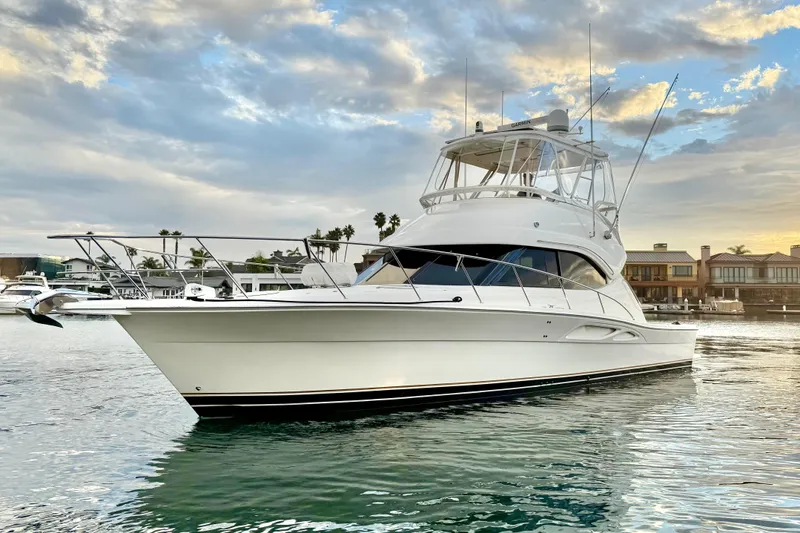 Slide: The Image of 2001 Riviera 40 Flybridge yacht on calm water at sunset, showcasing elegant design. - 5