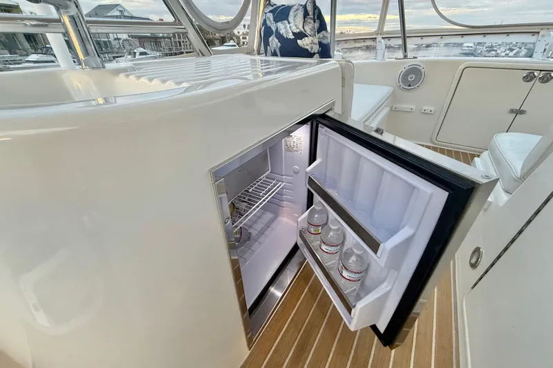Slide: The Image of Open mini fridge on 2001 Riviera 40 Flybridge yacht with water bottles inside. - 52